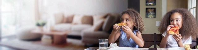 Dos niñas comiendo pizza