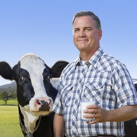 El agricultor Dave con una vaca y un vaso de leche marca Lactaid