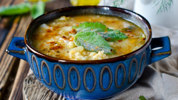 Recipiente de sopa de verduras con crutones al curry 